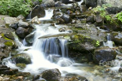 Small mountain waterfall among the rocks. 