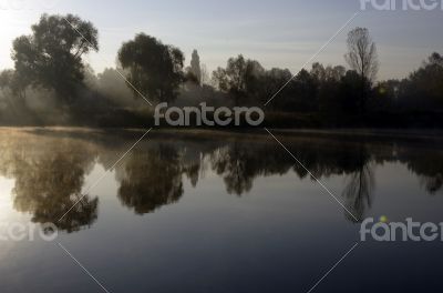 Foggy morning landscape in the autumn park near the lake. Vintag