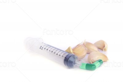 Herbal pills and garlic on a light colored background