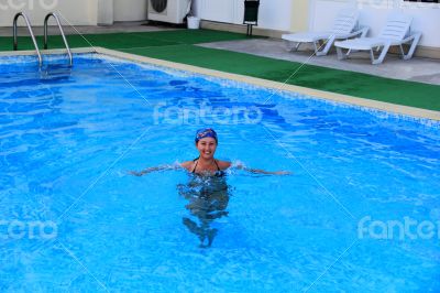 Smiling girl sailling in pool in kerchief