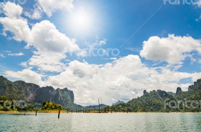 Sun over lake and mountain
