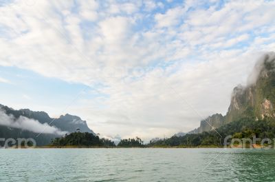 Sky above the mountains and green lake