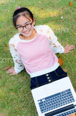Cute girl is happy with notebook on grass