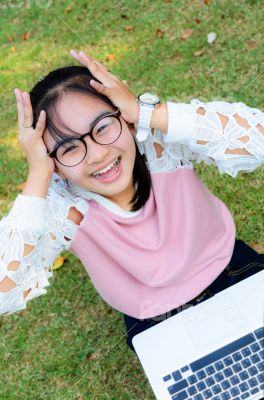 Cute girl is happy with notebook on grass