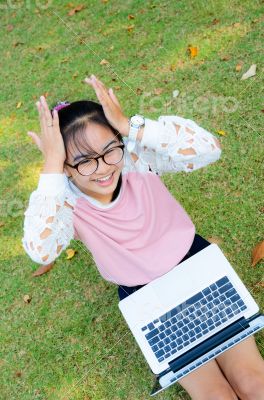 Cute girl is happy with notebook on grass