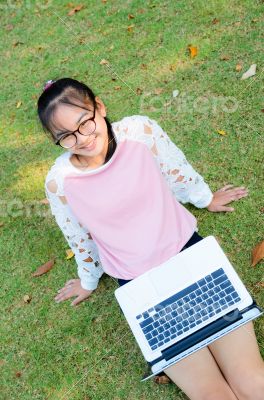 Cute girl is happy with notebook on grass