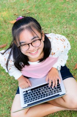 Lovely girl with a laptop on the grass