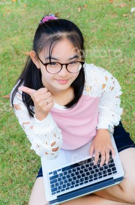 Lovely girl with a laptop on the grass
