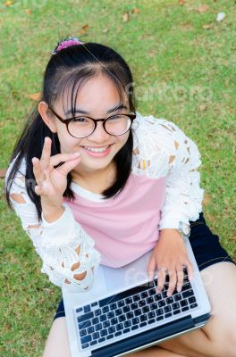 Lovely girl with a laptop on the grass