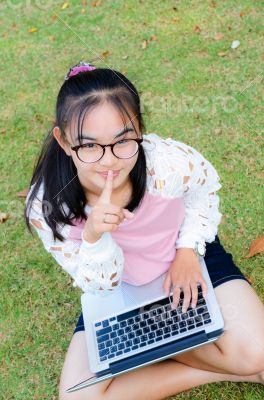 Lovely girl with a laptop on the grass