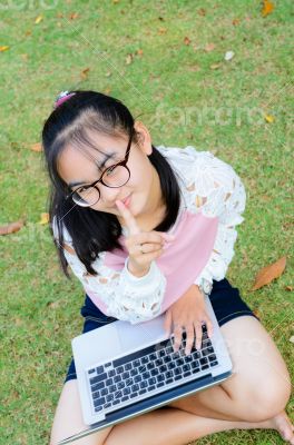 Lovely girl with a laptop on the grass