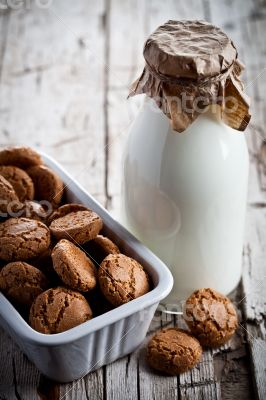 meringue almond cookies in a bowl and bottle of milk 