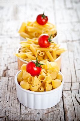 uncooked pasta and cherry tomatoes in three bowls 