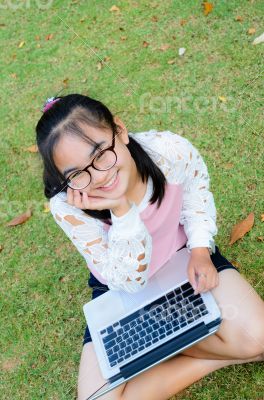 Lovely girl with a laptop on the grass
