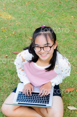 Lovely girl with a laptop on the grass
