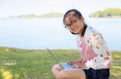 Young girl with laptop on the grass