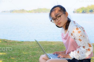 Young girl with laptop on the grass