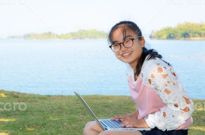 Young girl with laptop on the grass