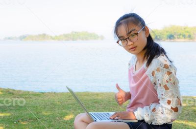 Young girl with laptop on the grass