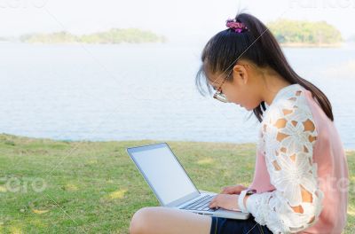 Young girl with laptop on the grass