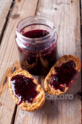 black currant jam in glass jar and crackers