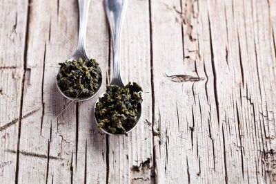two spoons of dried green tea leaves 