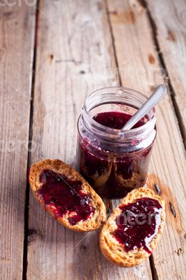 black currant jam in glass jar and crackers 