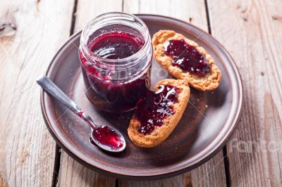 black currant jam in glass jar and crackers