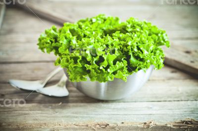 lettuce salad in metal bowl and spoons