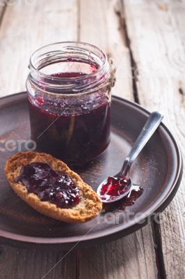 black currant jam in glass jar and crackers