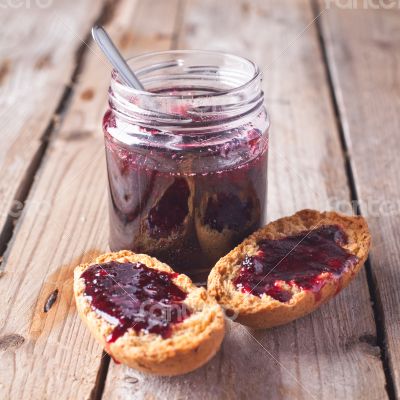 black currant jam in glass jar and crackers 