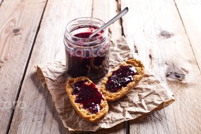 black currant jam in glass jar and crackers