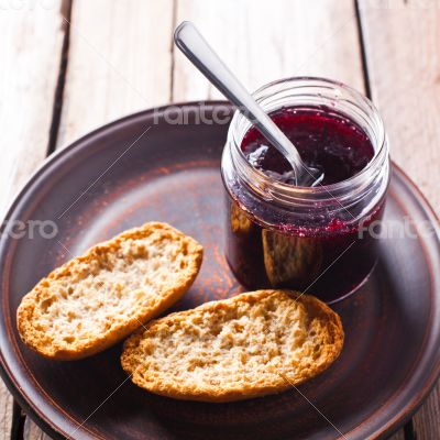 black currant jam in glass jar and crackers 