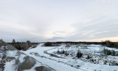 Panorama of an abandoned stone pit in winter 