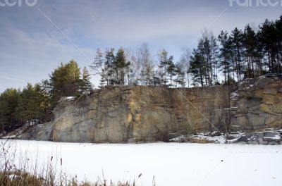 Panorama of an abandoned stone pit in winter 