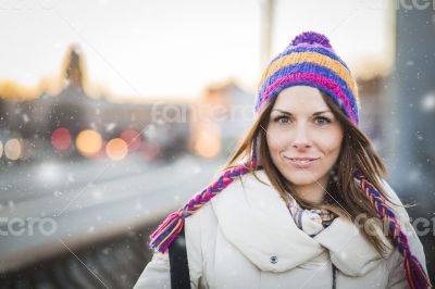 Positive girl with colorfull hat in winter city