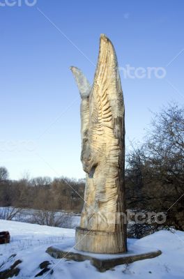 isolated totem wood pole in the blue cloudy background 