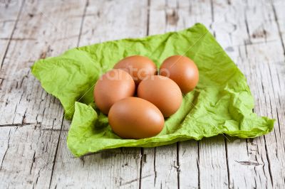  fresh brown eggs on green napkin 