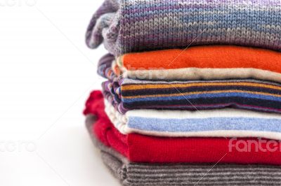Pile of woolen jumpers of various colors and textures 