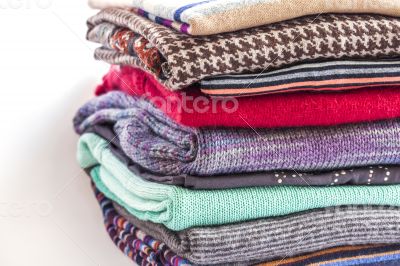 Pile of woolen jumpers of various colors and textures