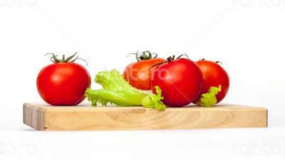 Red juicy tomatoes and lettuce leaves