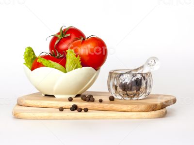 Red juicy tomatoes, lettuce leaves and black pepper