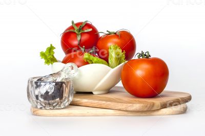 Red juicy tomatoes, lettuce leaves and black pepper
