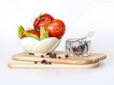 Red juicy tomatoes, lettuce leaves and black pepper