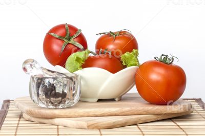 Red juicy tomatoes, lettuce leaves and black pepper