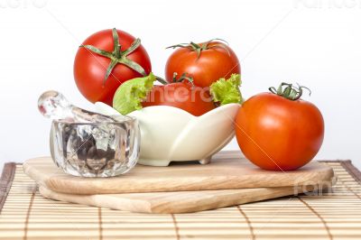 Red juicy tomatoes, lettuce leaves and black pepper