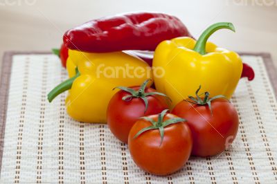Large paprika of red and yellow color and fresh tomatoes