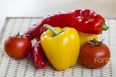 Large paprika of red and yellow color and fresh tomatoes