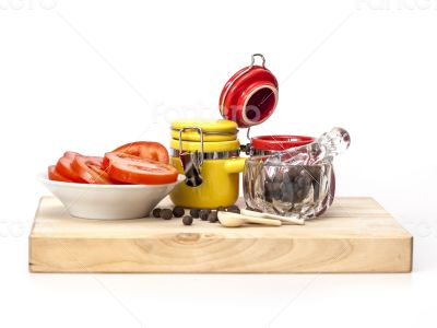 Black pepper, slices of tomato and containers