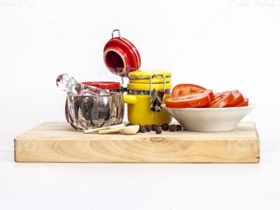 Black pepper, slices of tomato and containers